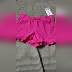 Little girl pull on shorts